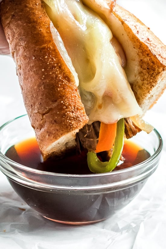 Slow Cooker French Dip Sandwich with Caramelized Onions filled with beef, melted cheese and au jus (beef broth) for dipping.