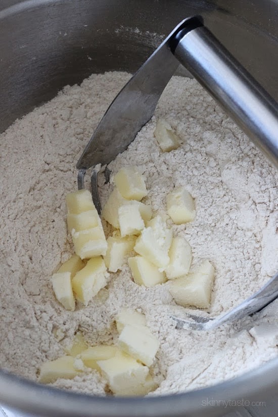 Dry ingredients mixed in with butter using pastry cutters.