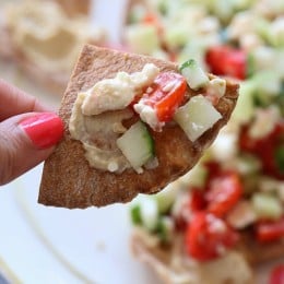 These Greek Nachos are a lighter, healthier Greek twist on traditional nachos – made with whole wheat pita chips, hummus, cucumbers, tomatoes and feta.