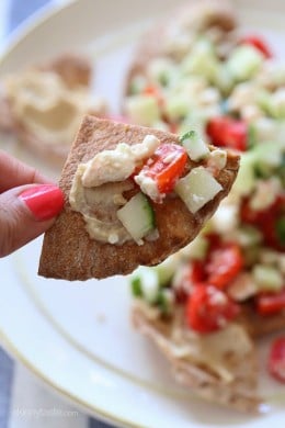 These Greek Nachos are a lighter, healthier Greek twist on traditional nachos – made with whole wheat pita chips, hummus, cucumbers, tomatoes and feta.