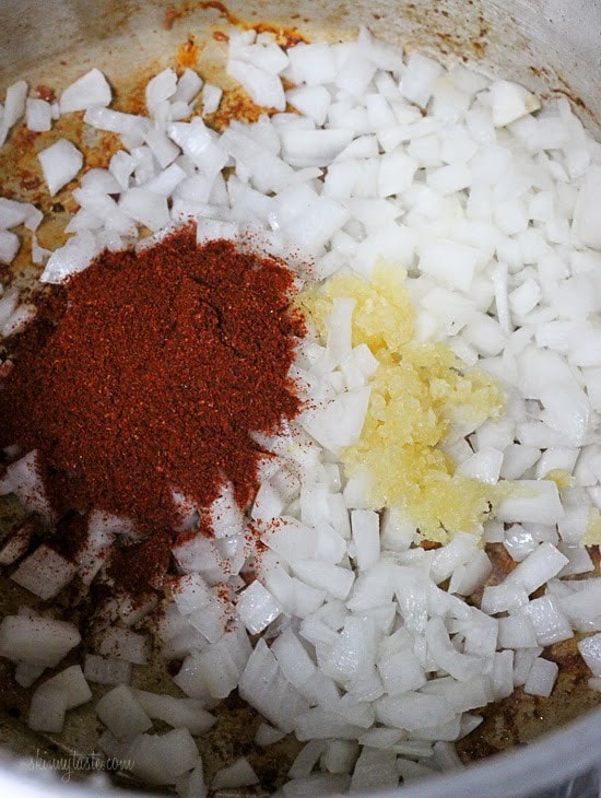 Diced onion, garlic, and chili powder in the bottom of an instant pot