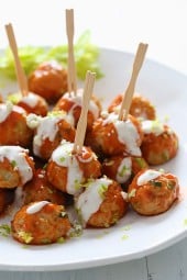 Buffalo Chicken Meatballs are perfect for football season! Made with minced celery and carrots hidden inside, topped with hot sauce, and homemade blue cheese dressing – yum!
