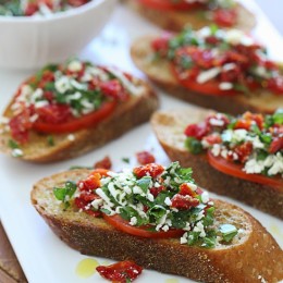 Super easy two tomato bruschetta made with roma and sun dried tomatoes, basil and feta cheese over toasted whole wheat bread.