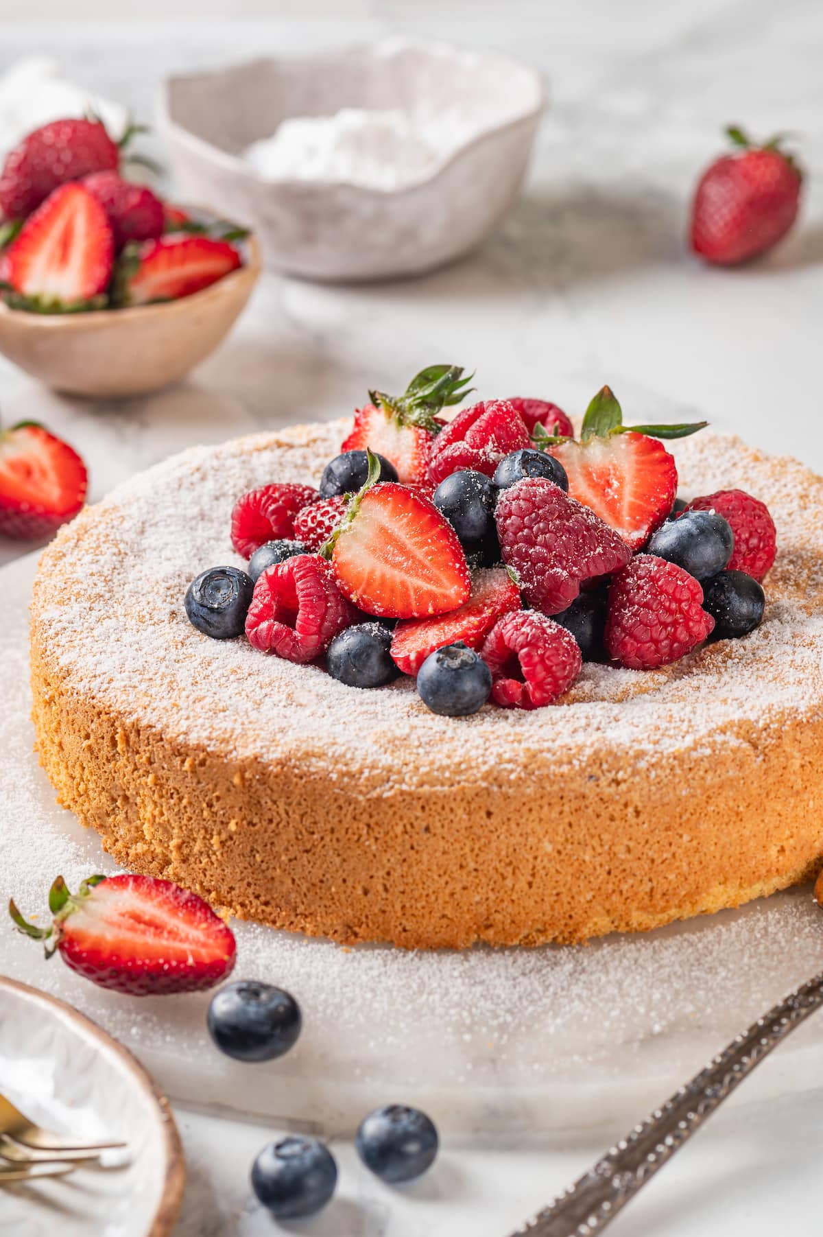 Almond cake with fresh berries and powdered sugar