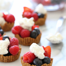 Perfect summer treat, these tartlets are made with a graham cracker crust, drizzled with dark chocolate and filled with fresh berries