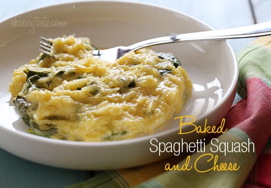 A bowl of cheesy baked spaghetti squash with pieces of chopped spinach.