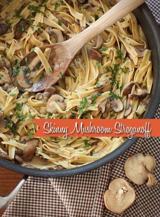 A skillet of pasta ribbons and sliced mushrooms in a creamy sauce sprinkled with fresh parsley.