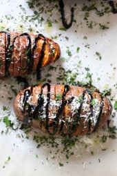 These sweet potatoes are sliced and roasted in the oven, then drizzled with balsamic and topped with parmesan and fresh herbs.