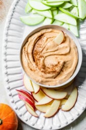 Pumpkin pie dip surrounded by sliced apples on a serving platter.