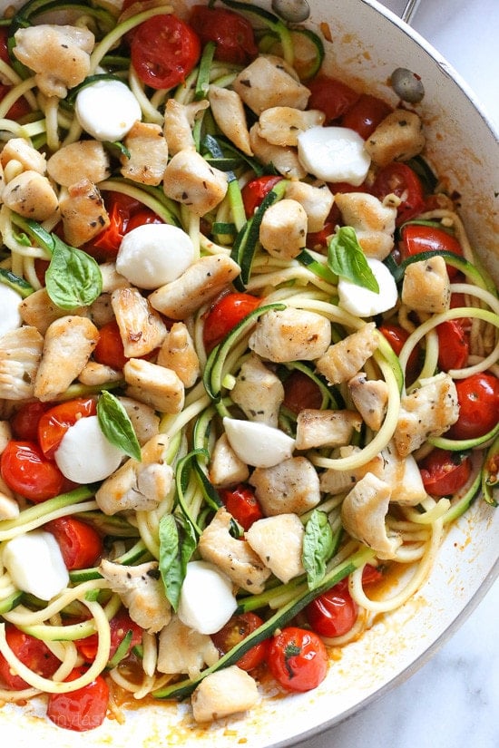 Chicken and Zucchini Noodle Caprese is made with sauteed bite-sized chicken breast and grape tomatoes cooked with spiralized zucchini, fresh mozzarella and basil. An easy, low-carb 30-minute meal!