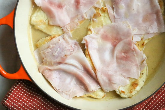 This EASY Skillet Chicken Cordon Bleu recipe is made with thin sliced boneless chicken cutlets, lightly pan fried then topped with ham and Swiss in a light Lemon-Dijon Sauce. No rolling!