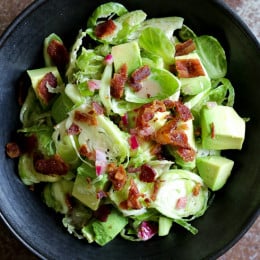 This shredded raw brussels sprout salad with bacon and avocado can be eaten as a main or a side dish. Because raw brussels stand up so well to dressing, it's also great to make ahead – just add the avocado right before serving.