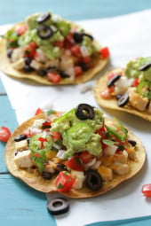 These easy loaded chicken "nacho" tostadas – topped with cheese, tomatoes, guacamole, olives and jalapenos are a great way to take nachos and turn them into a main dish.