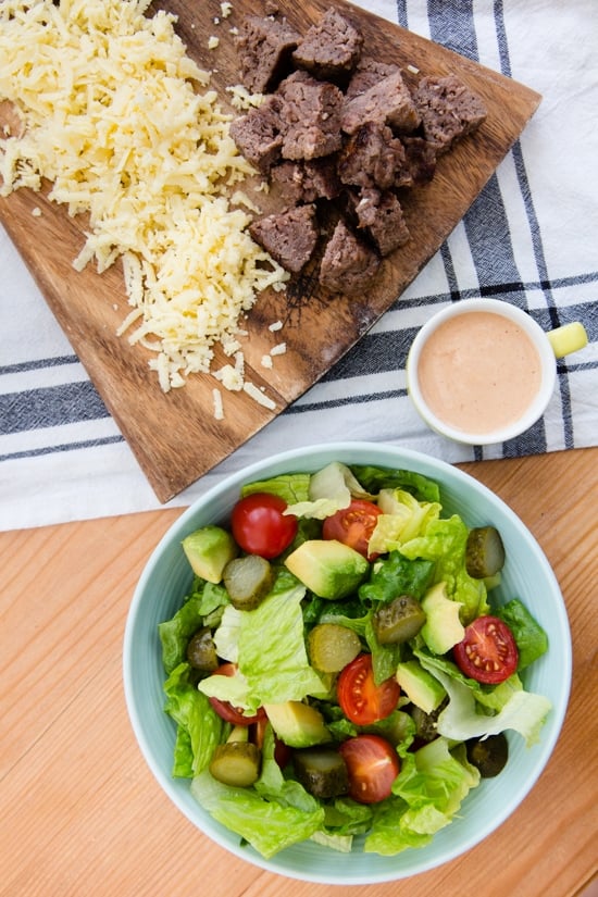 This salad has everything I love about a cheeseburger, sans the bun. Chopped romaine, tomatoes, avocado, pickles, shredded cheese topped with grilled burgers, red onions and drizzled with a seriously delicious dressing.