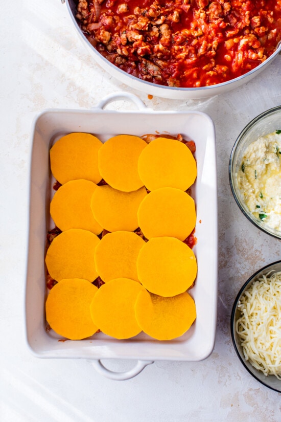 Butternut Squash in a casserole dish with marinara sauce and cheese