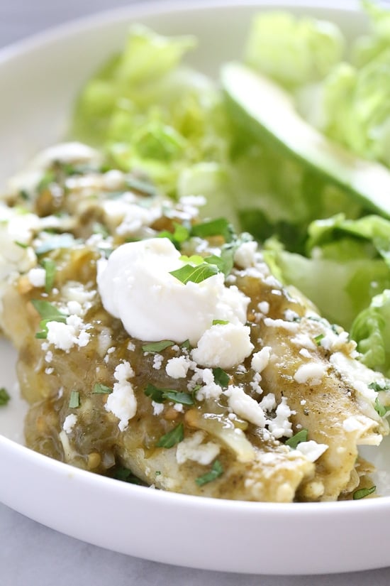 Traditional Mexican green chicken enchiladas, made lighter than the typical restaurant dish served throughout the US. Made with white corn tortillas, poached chicken breasts and a light coating of queso fresco, this dish is satisfying but won’t weigh you down.