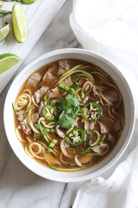 A quick, flavorful Vietnamese-inspired nood-less pho subs zucchini for rice noodles. So easy, the steak is sliced thin and cooks less than a minute in the ginger-garlic beef broth. Top this with fresh lime, basil, cilantro, jalapeno and scallions and you have one tasty faux pho!