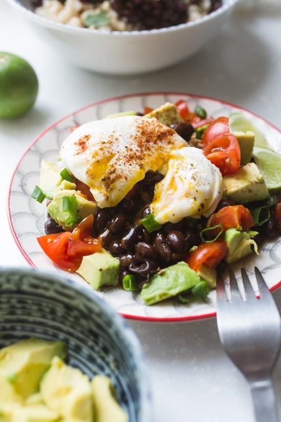 Black beans with a poached egg over avocado and tomato