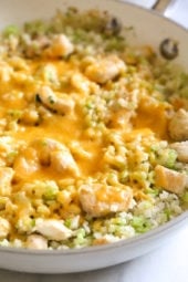 Skillet Cheesy Chicken and Veggie "Rice" made with riced broccoli and cauliflower, sauteed chicken and cheddar cheese. It's so fast and easy to make!