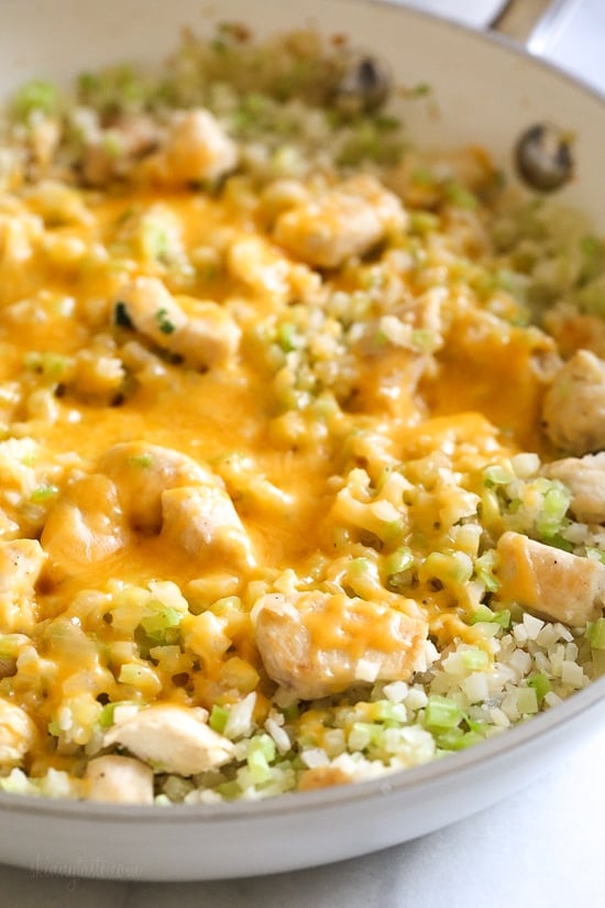 Skillet Cheesy Chicken and Veggie "Rice" made with riced broccoli and cauliflower, sauteed chicken and cheddar cheese. I whipped this up for dinner the other night and my daughter loved it! It's so fast and easy to make I knew I had to share.