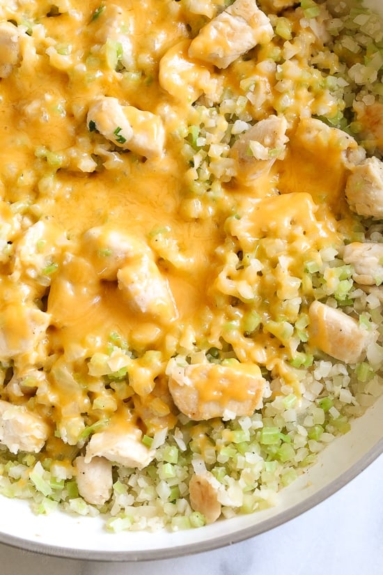 Skillet Cheesy Chicken and Veggie "Rice" made with riced broccoli and cauliflower, sauteed chicken and cheddar cheese. It's so fast and easy to make!