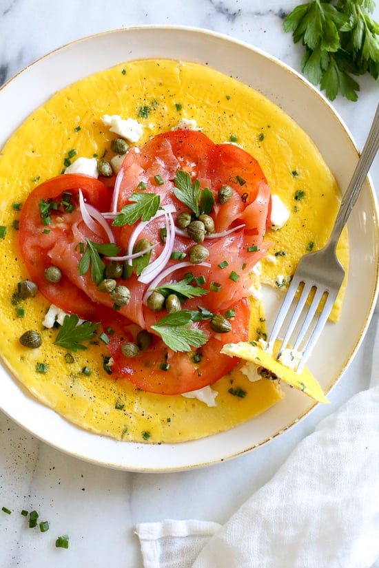 This Goat Cheese Herb Omelet topped with Nova Lox, sliced tomatoes and capers satisfies my bagel-and-lox craving, without the bagel! SO quick, takes about 5 minutes to make!