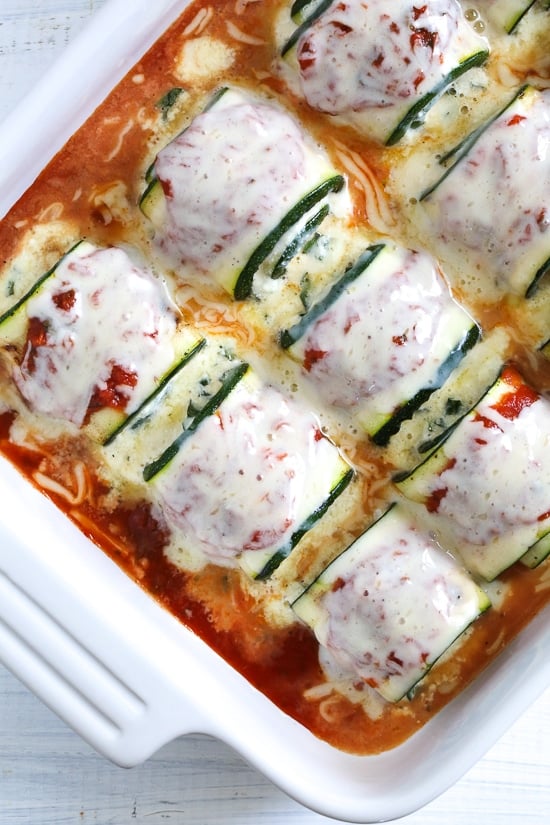 Noodle-less Zucchini Rollatini is low-carb and delicious! Made with strips of grilled zucchini stuffed with a basil-cheese filling, then rolled and topped with marinara, mozzarella and baked in the oven until the cheese is hot and melted.