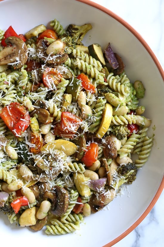 One bite of this Balsamic Roasted Veggie and White Bean Pasta and you'll want to make it all summer long! Roasted zucchini, yellow squash, mushrooms, peppers, and broccoli – loaded with veggies in every bite and finished with pesto and white beans. This is SO good, and picky husband approved!