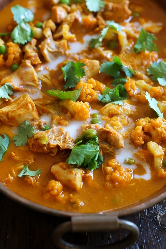 I've created a lightened up, dairy-free Chicken Tikka Masala with Cauliflower and Peas in the Instant Pot to satisfy my craving for Indian food! This mild curry is made with boneless chicken thighs cooked in a tomato base, with lots of spices and coconut milk. You can serve this with garlic naan or basmati rice on the side (cauliflower rice would work too to keep it low carb!)