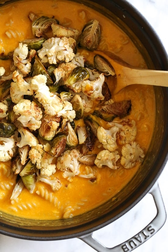 Creamy, Pumpkin Mac and Cheese with Roasted Veggies is comfort food, in a bowl! Made with pumpkin puree, roasted cauliflower and Brussels sprouts.