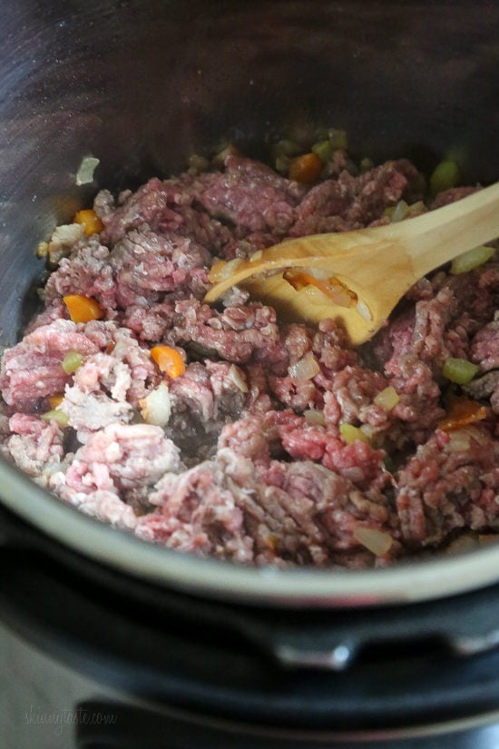Ground beef added to the Instant Pot with sauteed vegetables.
