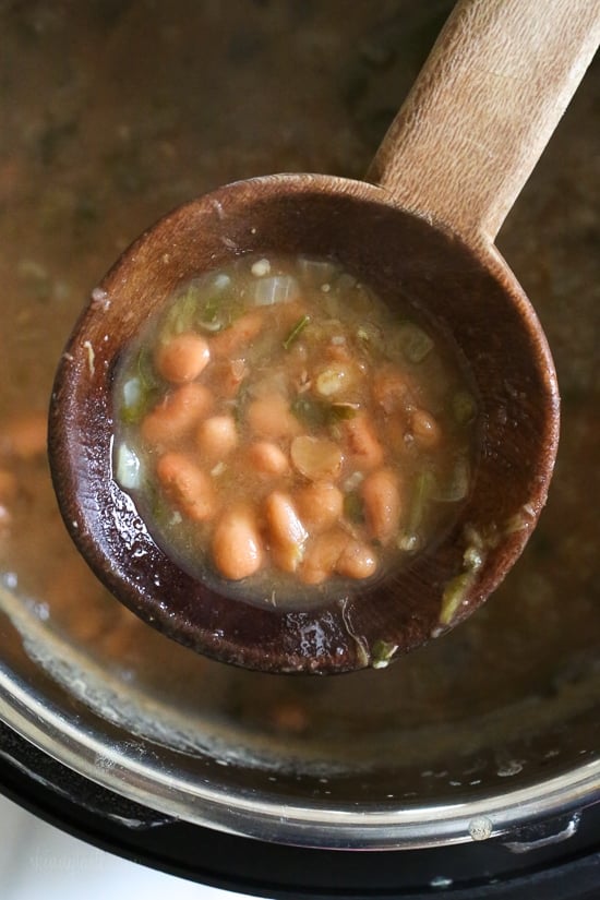 Mexican Pinto Beans, Frijoles Con Todo are made from scratch in the pressure cooker with dry pinto beans, onions, chile, jalapeno, tomatoes, cilantro, avocado and my favorite part, the queso! These soupy beans are not spicy, and can be served as a soup or as a side dish over rice or with tortillas.