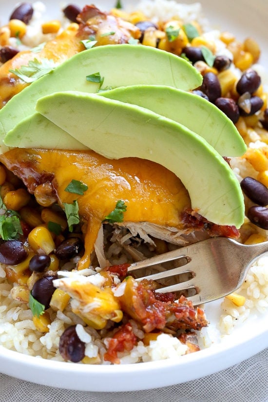 This EASY Slow Cooker Chicken dish is cheesy and delicious, made with ،less chicken ،, black beans, corn and salsa topped with melted cheddar cheese. YUM!