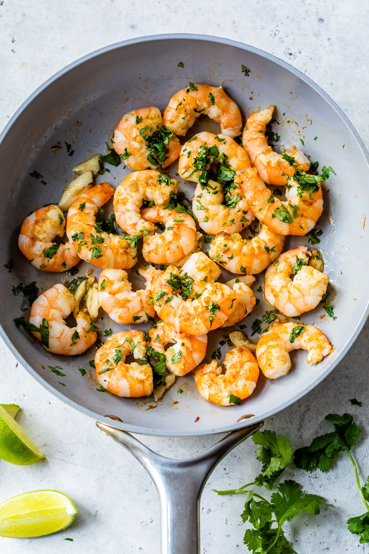 shrimp in a skillet with lime and cilantro