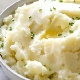 A bowl of creamy Instant Pot mashed potatoes topped with chopped chives.