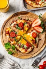 Sliced breakfast pizza topped with runny egg.