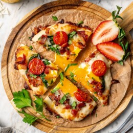 Sliced breakfast pizza topped with runny egg.