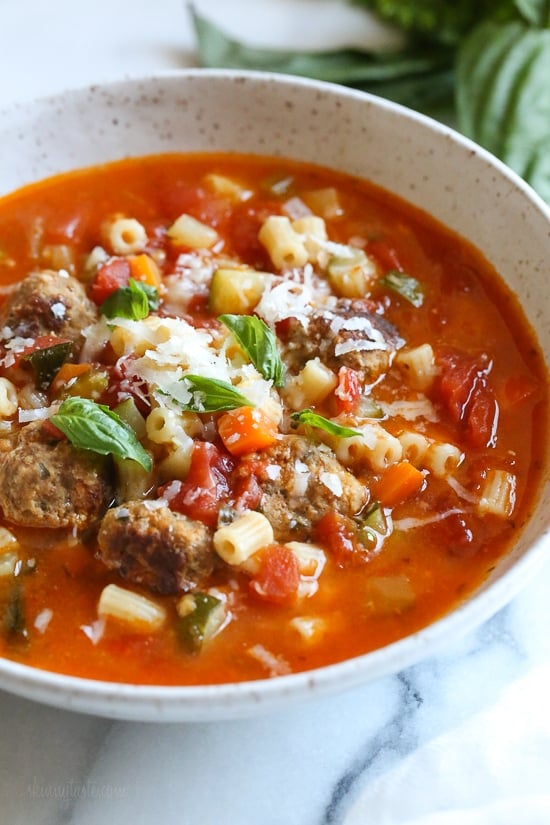 A bowl of turkey meatball soup topped with grated parmesan