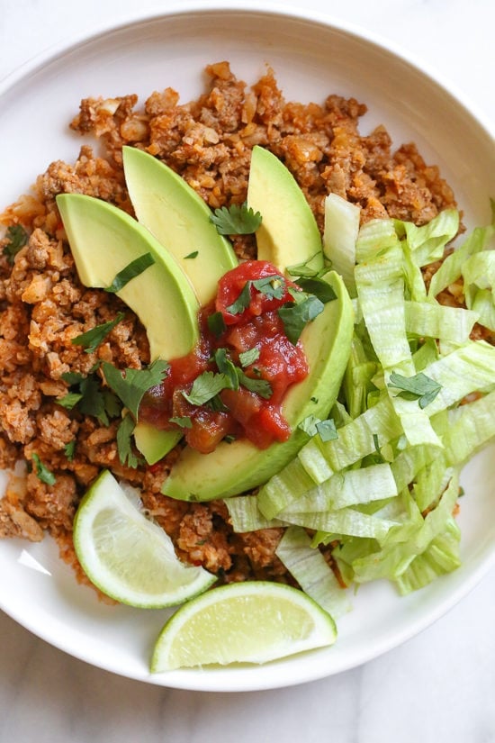 This easy skillet dinner combines ground turkey taco meat with cauliflower rice topped with lettuce, avocado and salsa for an easy, low-carb weeknight meal!
