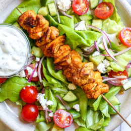 This Mediterranean inspired salad is made with Grilled Chicken Shawarma kebabs served over salad with Feta and Tzatziki.