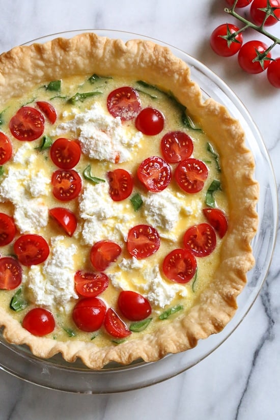 This vegetarian quiche recipe is made with spinach, ricotta cheese, eggs, tomatoes and basil. Perfect for breakfast, lunch or brunch or serve it with a salad for a light dinner.