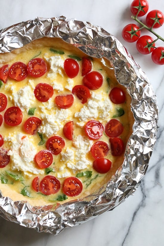 This easy vegetarian quiche recipe is made with spinach, ricotta cheese, eggs, tomatoes and basil. Perfect for breakfast, lunch or brunch or serve it with a salad for a light dinner.