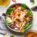 Grilled Chicken Salad with greens and vegetables are tossed in a honey-lime vinaigrette and topped with a delicious peanut sauce.