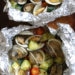 Grilled little neck clams cooked in foil packets with zucchini and tomatoes in a garlic white wine sauce, so fast and easy, perfect to make all summer long!