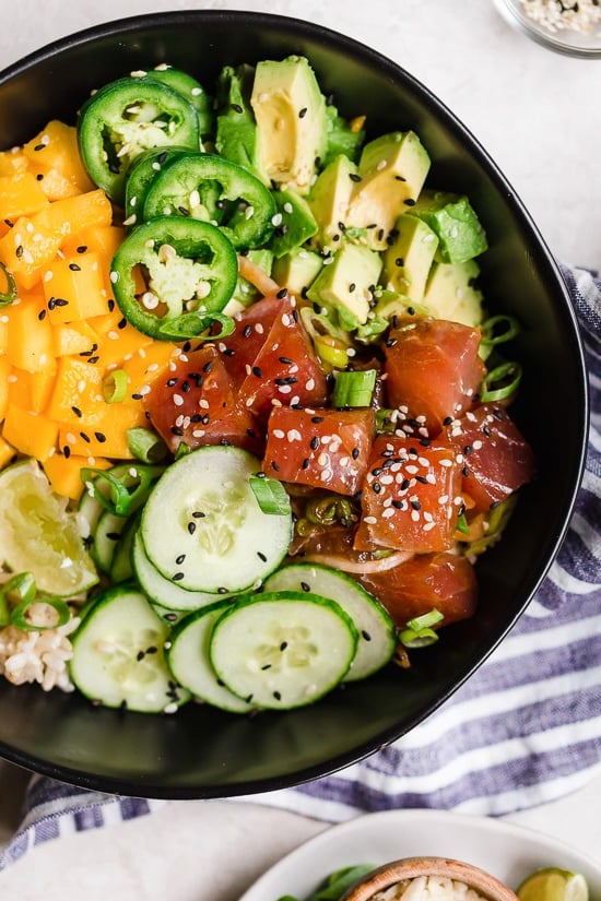 With marinated tuna, brown rice, avocado, cucumber, mango, macadamias and scallions, this Hawaiian style quick-cook Ahi Poke Bowl is perfect for hot summer nights. 