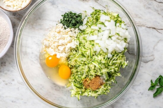 These easy zucchini fritters are crunchy, cheesy, and full of Mediterranean flavor! Serve as a summer side dish, appetizer, or light meal. Place pumpkin fry ingredients in a bowl before mixing.