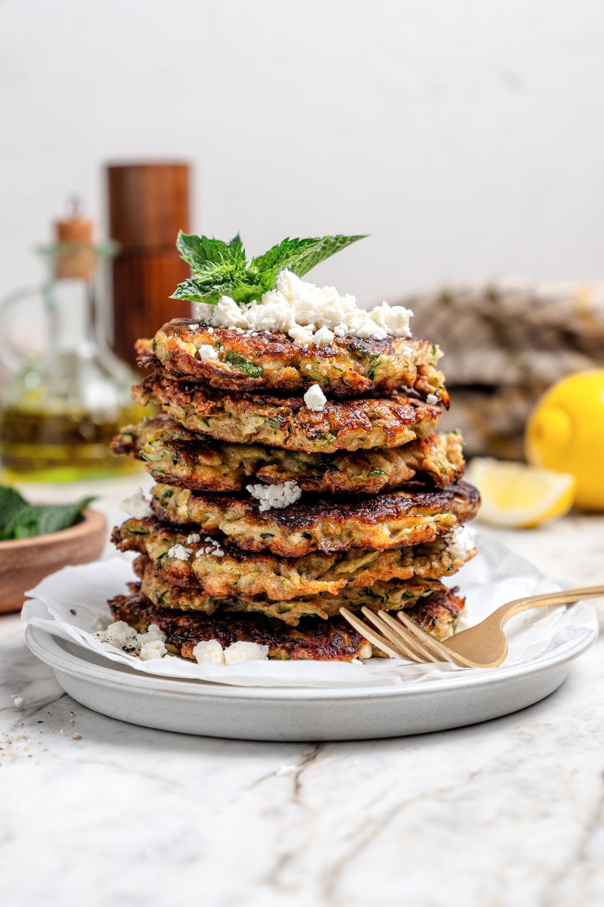 These easy zucchini fritters are crunchy, cheesy, and full of Mediterranean flavor! Serve as a summer side dish, appetizer, or light meal. Pile a plate of pumpkin fritters with feta and mint.