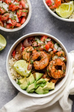These Shrimp Fajita Bowls are a tasty and easy dinner that your whole family will love! Served over a bed of cilantro-lime rice with peppers and onions, avocado and salsa.