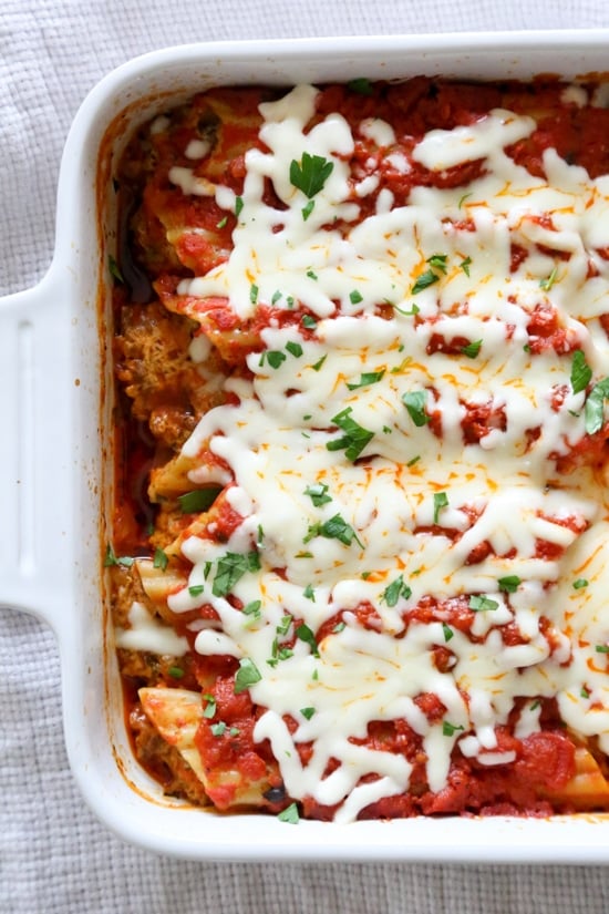 This easy no-boil baked manicotti pasta dish, known as Cannelloni is stuffed with ricotta, parmesan, mozzarella and lean ground beef, then covered in sauce and cheese. Perfect for the holidays, for to bring to a potluck or to enjoy any night of the week!