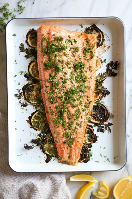 This simple Baked Salmon dish is made with fresh lemon, and lots of fresh herbs such as dill, parsley, chives.